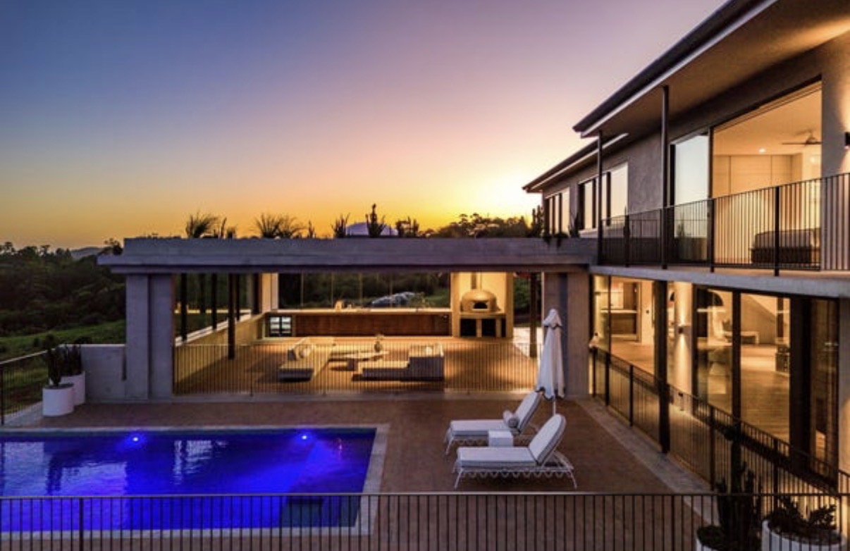 The illuminated pool terrace and entertaining area at sunset