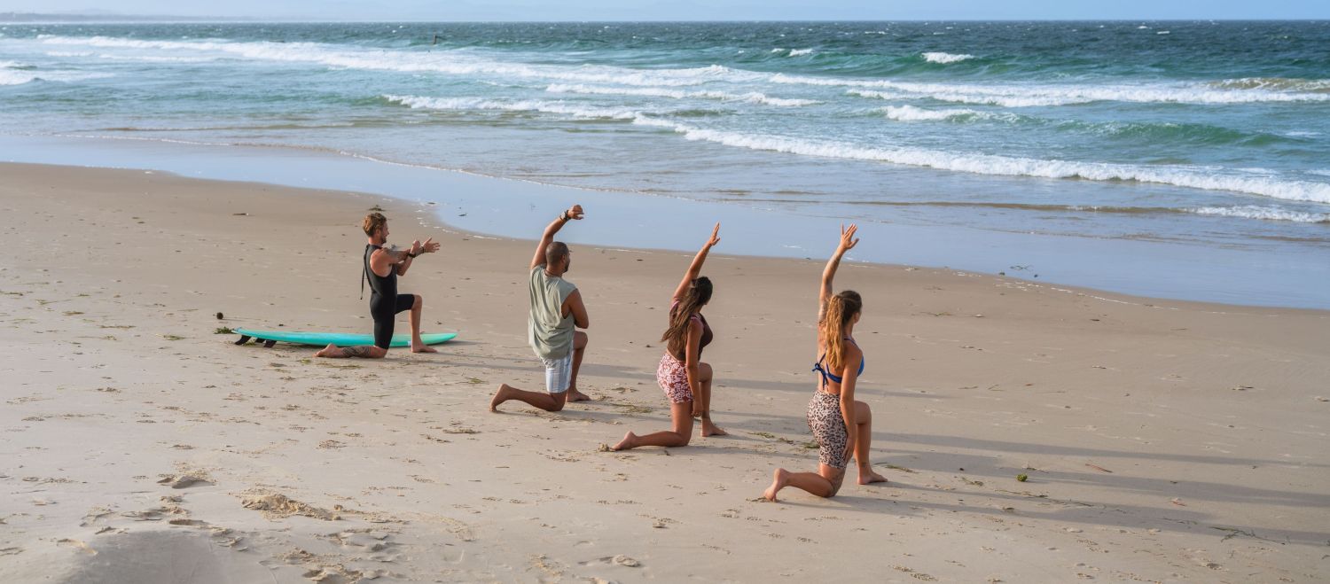 Friends stretching on Belongil Beach in Byron Bay